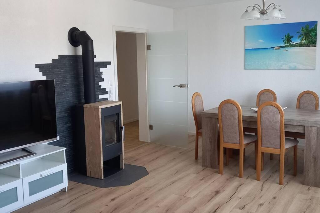 a living room with a dining room table and a television at Ferienwohnung für bis zu 10 Personen in Koetz 