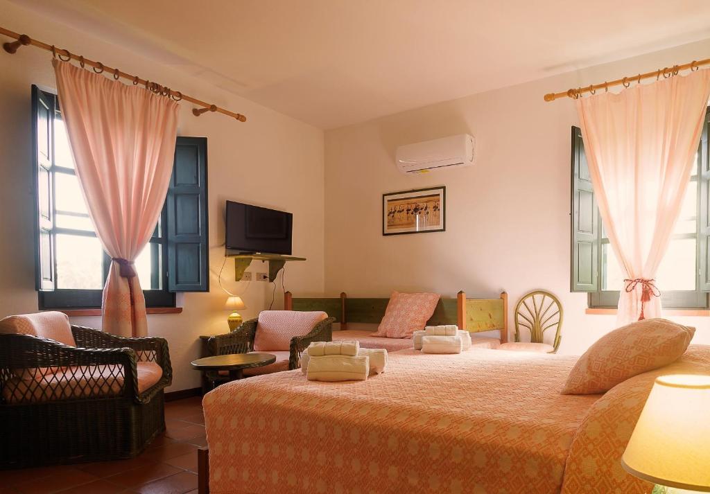 una camera con letto e un soggiorno di Hotel Ristorante Sa Pedrera a Càbras