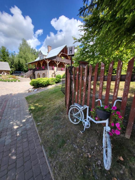 uma bicicleta estacionada ao lado de uma cerca com uma casa em Šilainė Recreation & Leisure em Oszkinie