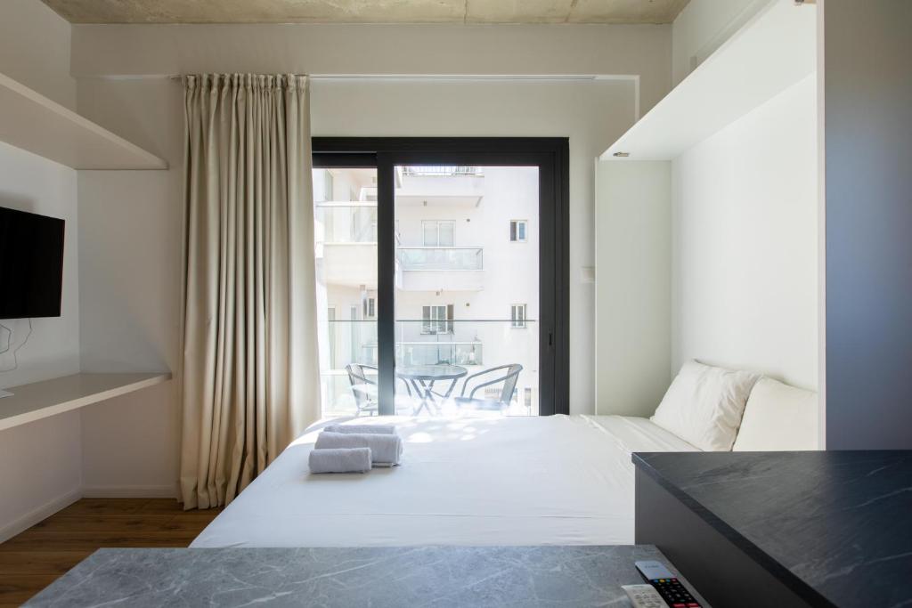a bedroom with a bed and a large window at YAMAS Urban LIving Spiridonos in Limassol