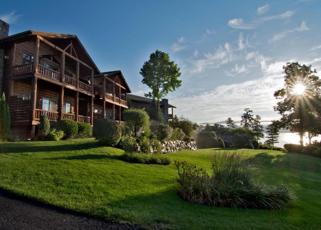 una casa su un prato verde di fronte a un edificio di The Lodges at Cresthaven a Lake George