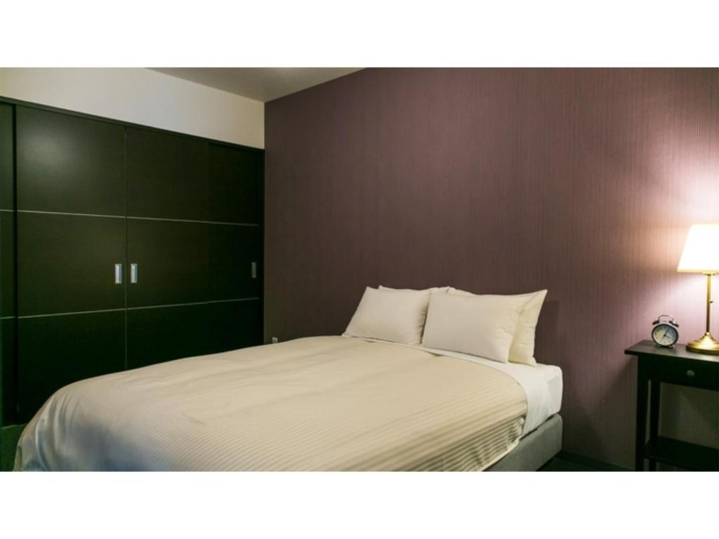 a bedroom with a large bed with white sheets at Kyoto Four Sisters Residence - Vacation STAY 15231v in Kyoto