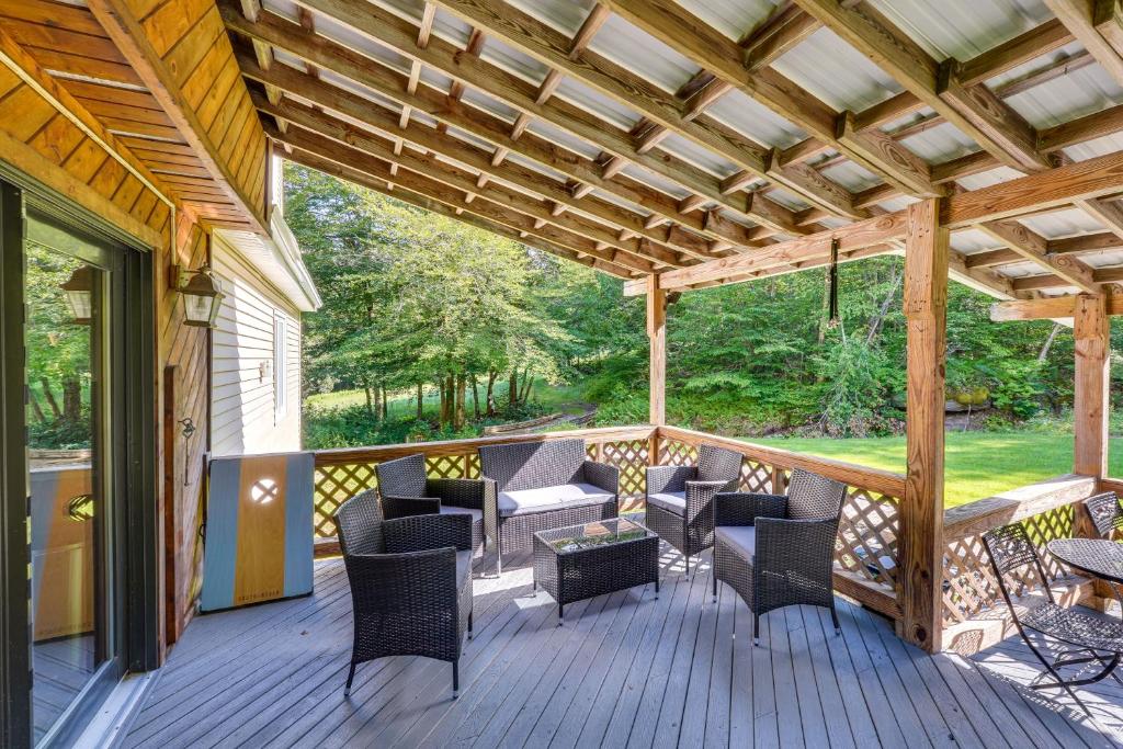 a covered deck with chairs and a table at Cozy Livingston Manor Home with Wood-Burning Stove! in Livingston Manor