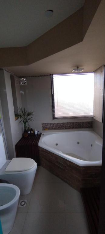 a bathroom with a tub and a toilet and a window at Homestays La Reinamora in San Salvador de Jujuy