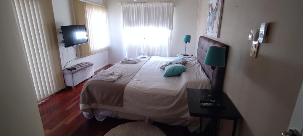 1 dormitorio con 1 cama y TV en Homestays La Reinamora en San Salvador de Jujuy