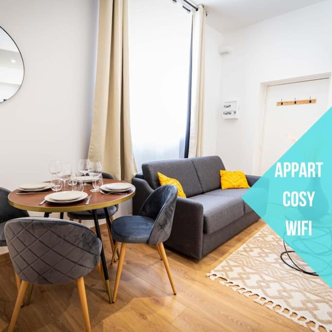 un salon avec une table et un canapé dans l'établissement L'Albatros 012 - Hypercentre * Cosy * Wifi, à Saint-Quentin