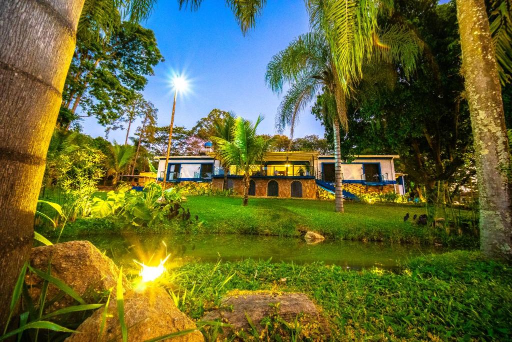 uma casa no meio de um quintal com palmeiras em Quinta D’ Aurora em Espírito Santo do Pinhal