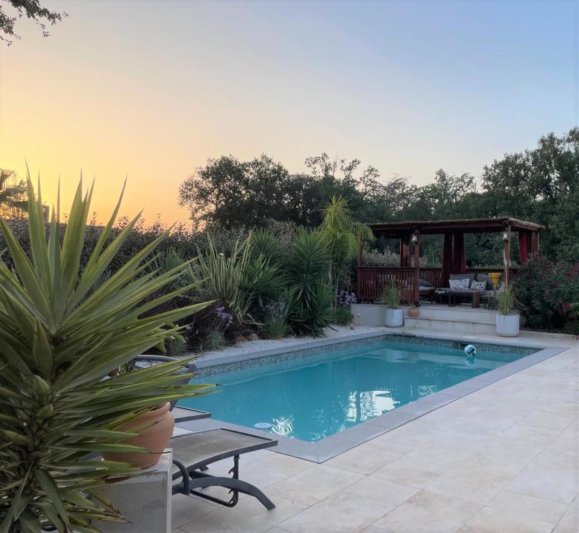 - une piscine dans un jardin avec une table et un banc dans l'établissement Villa SOANNE, à Bagnols-en-Forêt