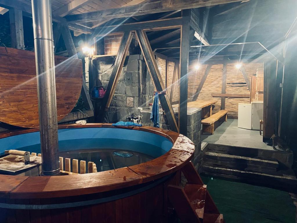 a large wooden tub in a room with stairs at Cabana Miska Chalet in Miercurea-Ciuc
