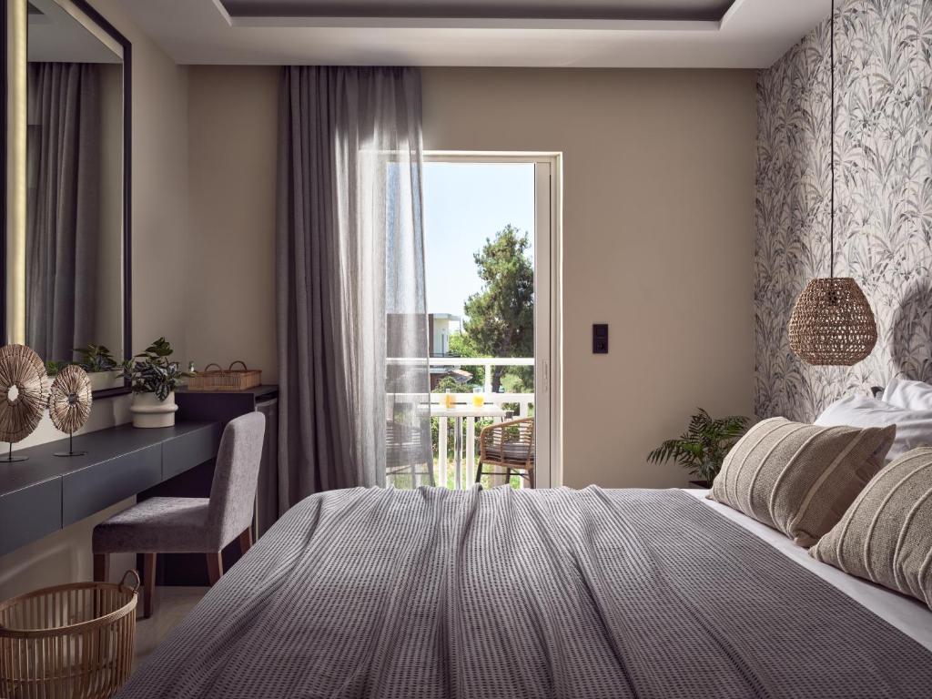 1 dormitorio con cama, escritorio y ventana en Nastazia Studios, en Laganas