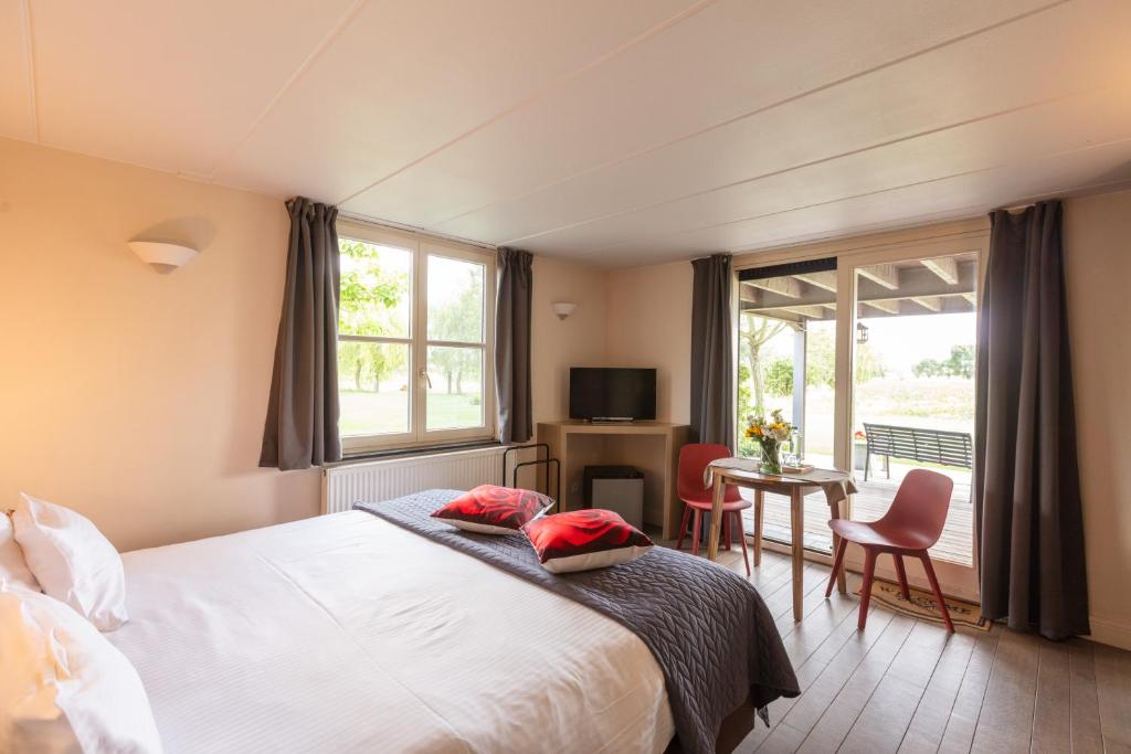 a bedroom with a bed and a table with chairs at B&B Het Eycken Huys in Aalter