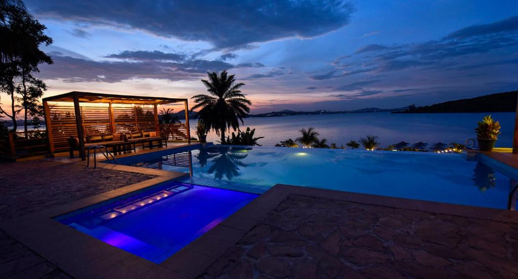 a swimming pool with a view of the water at night at Divine Resort & Spa in Kampala