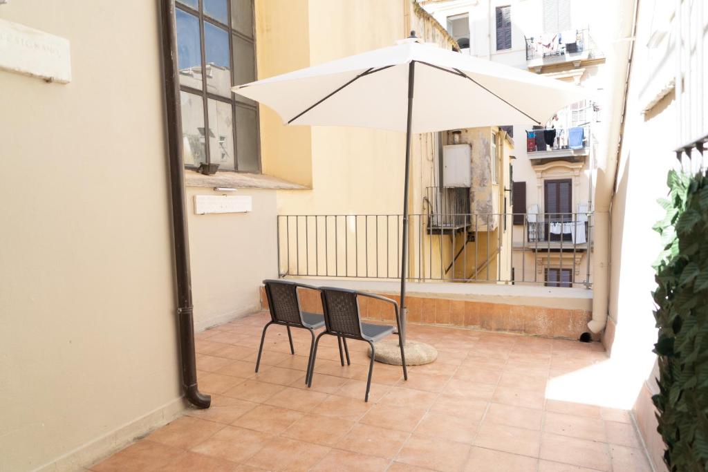 einen Tisch und Stühle mit Sonnenschirm auf dem Balkon in der Unterkunft GG-Grow - La Terrazza Di Bellavista in Neapel