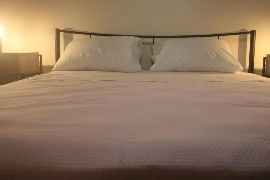 a large white bed with two pillows on it at Billy's appartment in Preveza