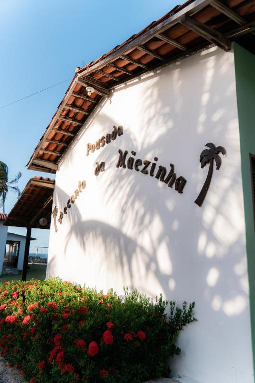 a sign on a building with a sign for a restaurant at Pousada Recanto da Mãezinha in Beberibe