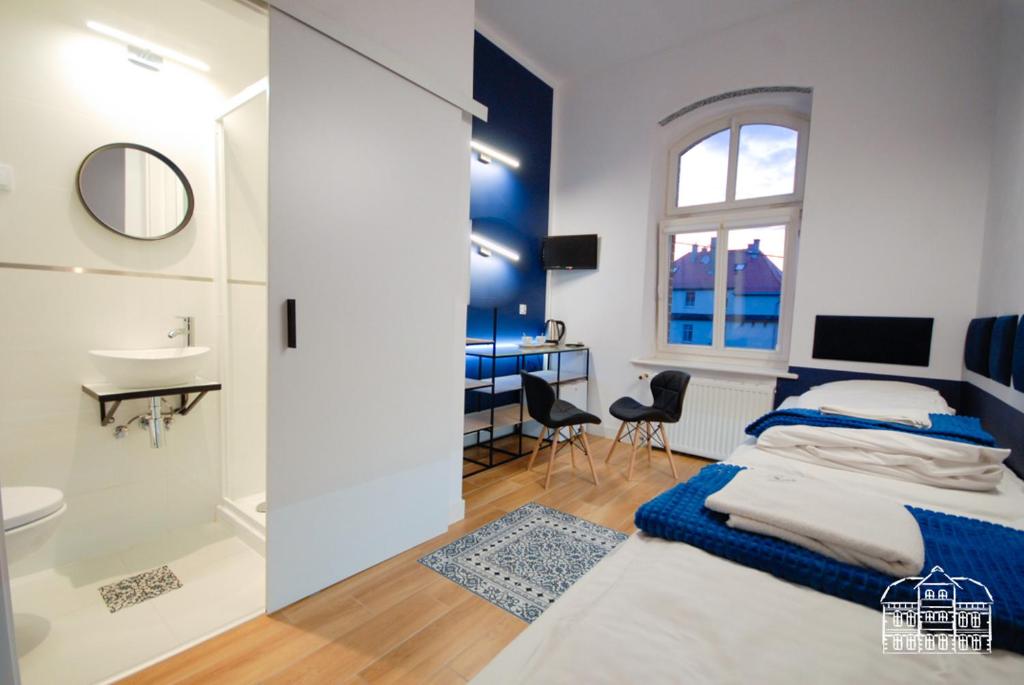 a bedroom with a bed and a bathroom with a sink at Pokoje Turystyczne przy Parku Szwedzkim in Szczawno-Zdrój