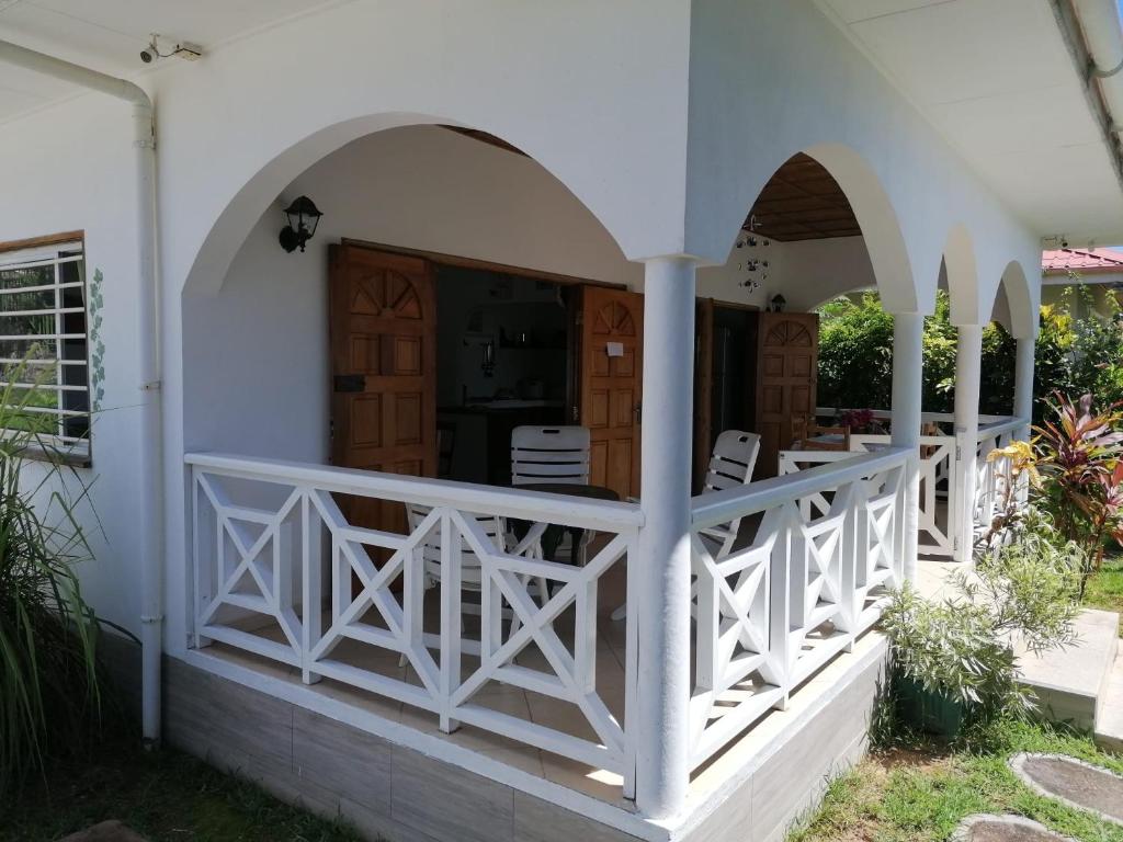 a white house with arches and a porch at Maison de Vacanze in Baie Sainte Anne