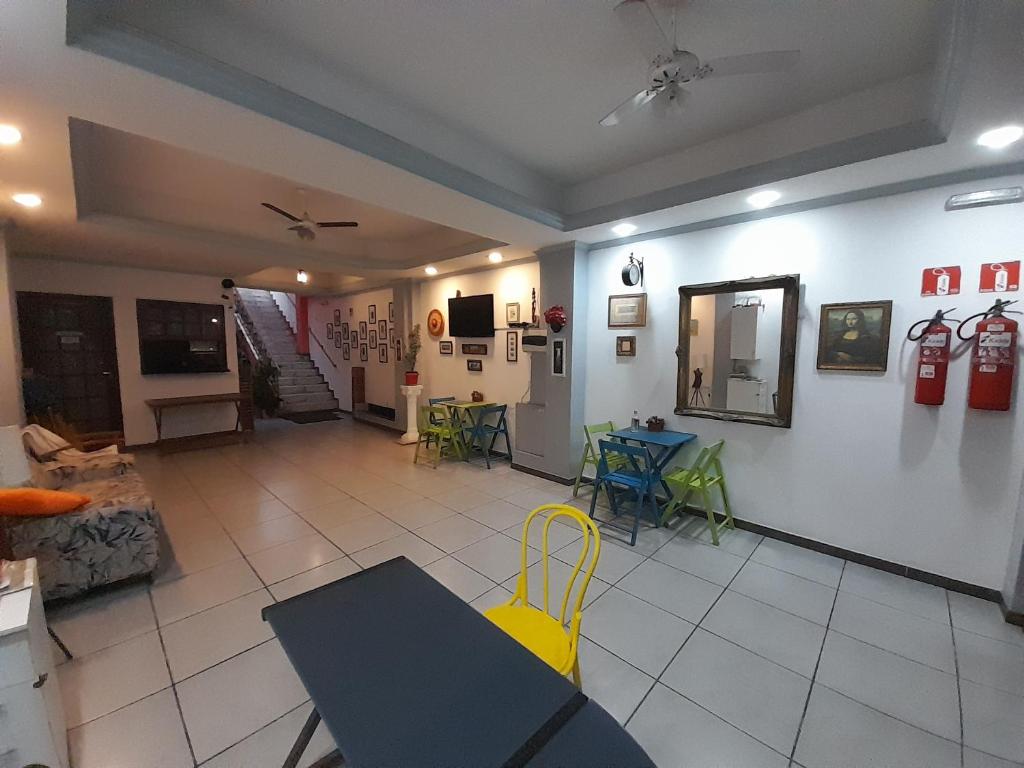 uma sala de estar com uma cadeira amarela e uma mesa em Albergue Rio Vermelho em Salvador
