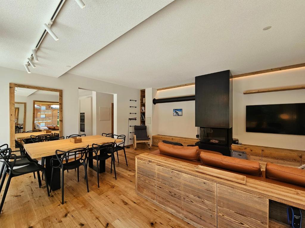 ein Esszimmer mit einem Tisch und einem Flachbild-TV in der Unterkunft Riverside 1st Floor South in Saas-Fee