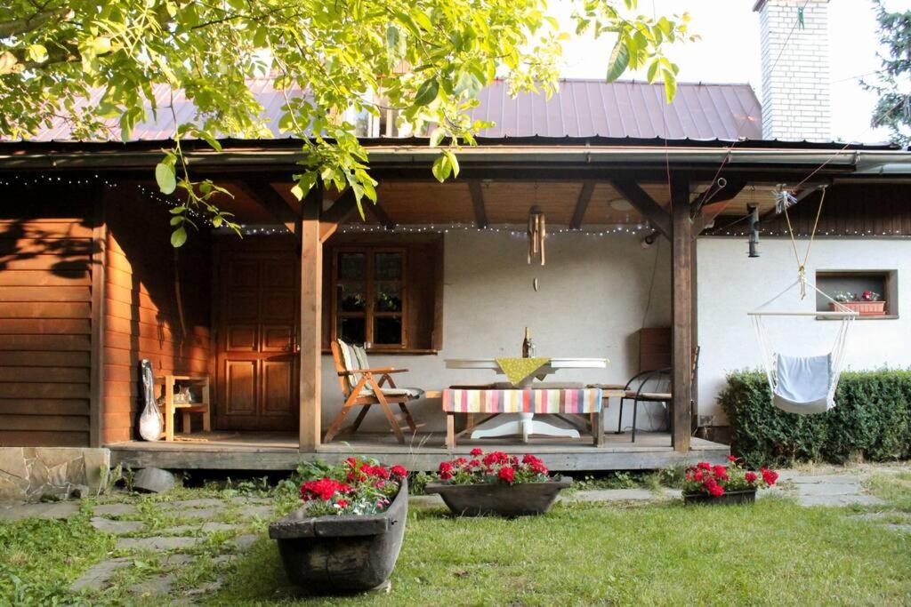 eine Veranda eines Hauses mit einem Tisch und Stühlen in der Unterkunft Dřevěnice u Azzyho in Lačnov