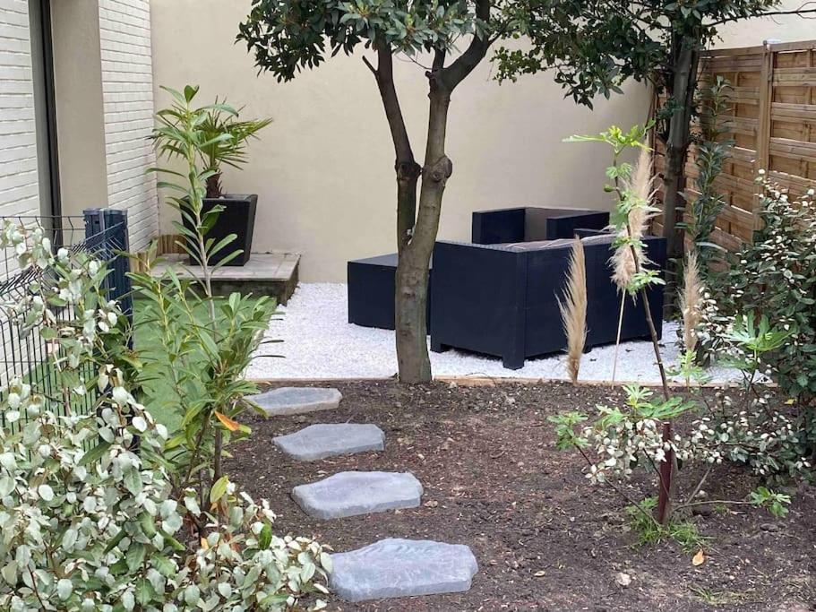un jardin avec un arbre et quelques rochers dans l'établissement Studio équipé en rez de jardin, à Villeurbanne