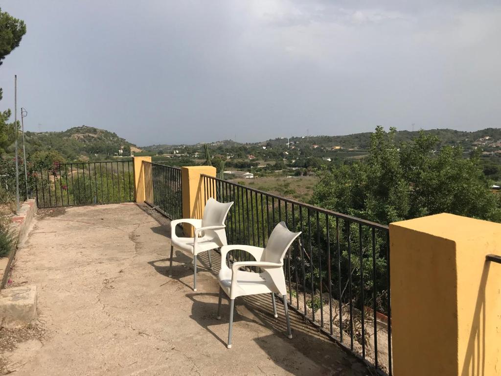 two white chairs sitting on a balcony with a view at Los Pinos in Alginet