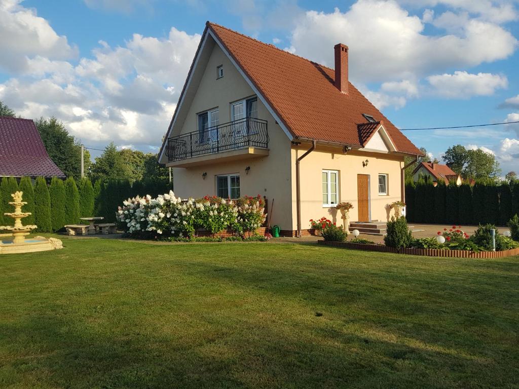 a white house with a yard with a grass yard at domek PERKUN in Pierkunowo