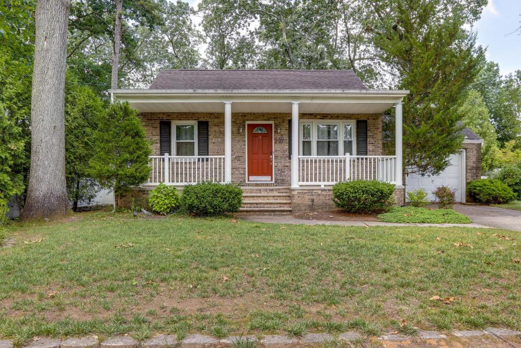 uma pequena casa com uma porta vermelha e um quintal em Charming Monroe Township Home - 13 Mi to RU! em East Brunswick