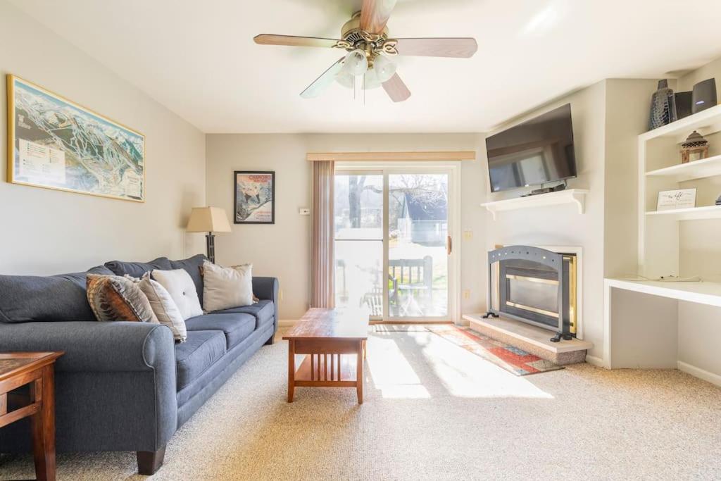a living room with a blue couch and a fireplace at SKIING, HIKING, VILLAGE OF EVILLE MTN ESCAPE in Ellicottville