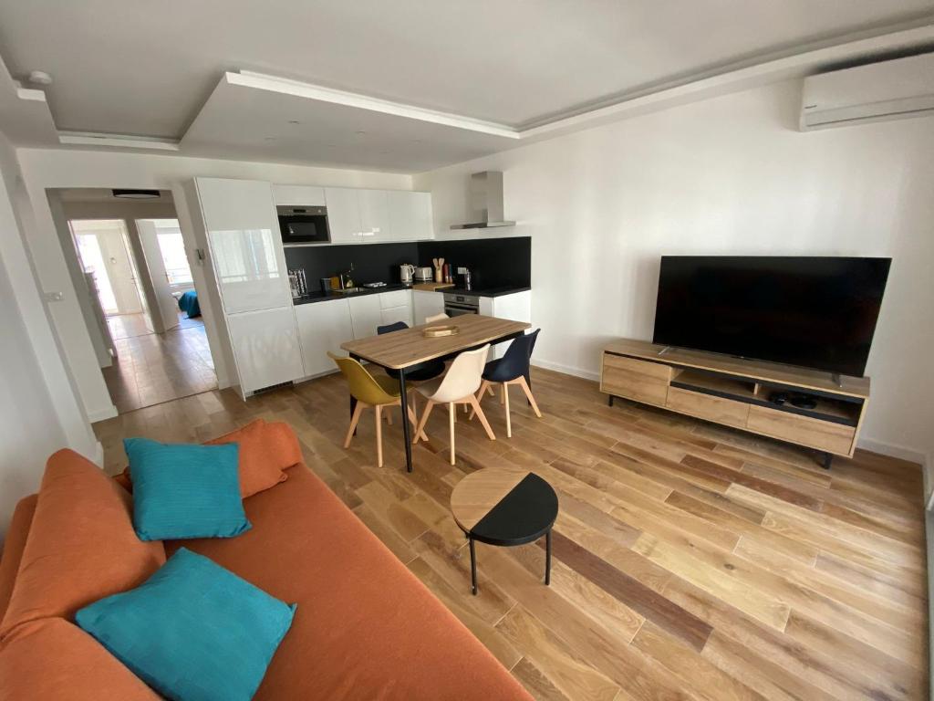 een woonkamer met een bank en een tafel met stoelen bij Renovated 4 room Apartment-Parking next door and Beach at 700m in Antibes
