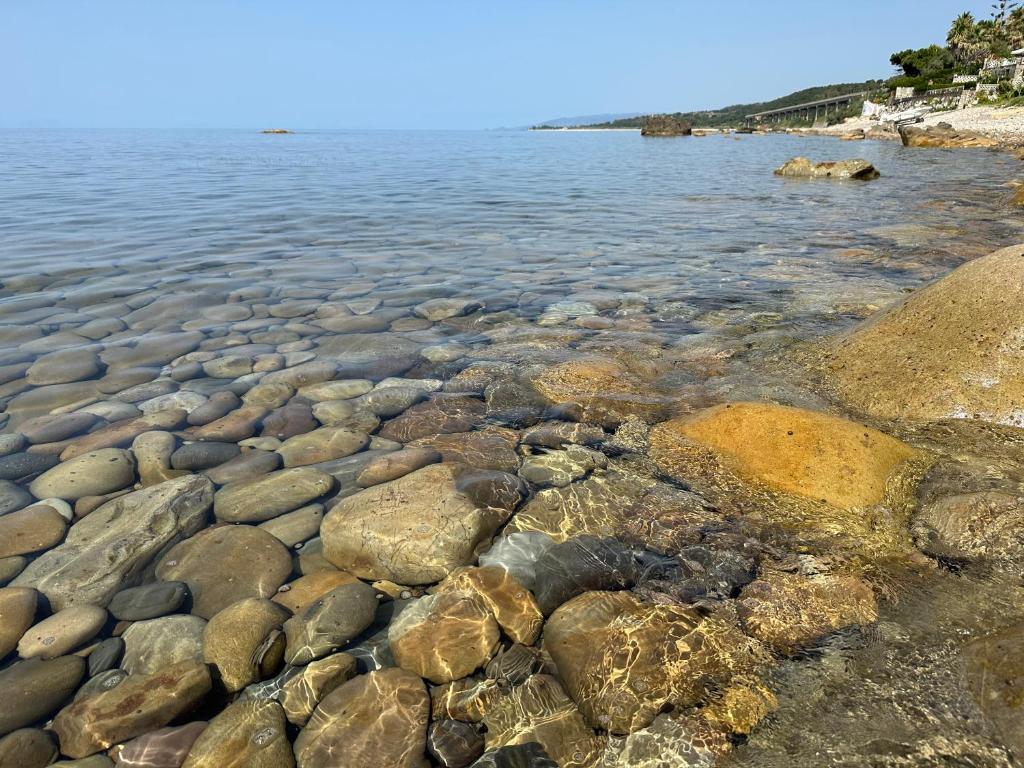 a group of rocks on the shore of a body of water at EmmeBi Appartamenti in Acquedolci