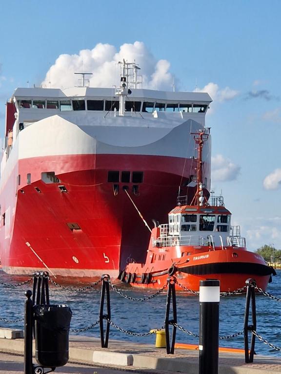 a large red and white ship in the water at Seaside in Gdańsk