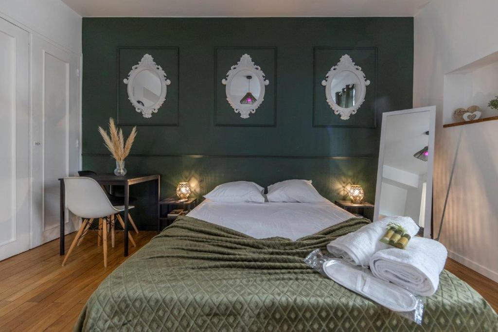 Un dormitorio con una cama con paredes verdes y espejos en La Maginot Room YourHostHelper, en Grenoble