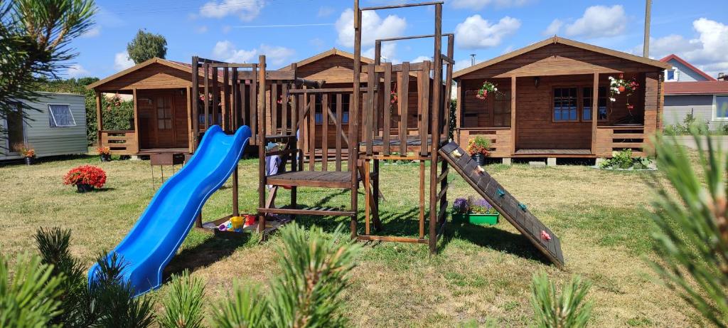 a playground with a slide in front of a house at Pas Jūratę namelių nuoma Šventojoje in Šventoji