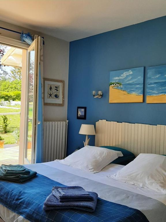 a bedroom with two beds and a blue wall at A la Volette in Pouillé