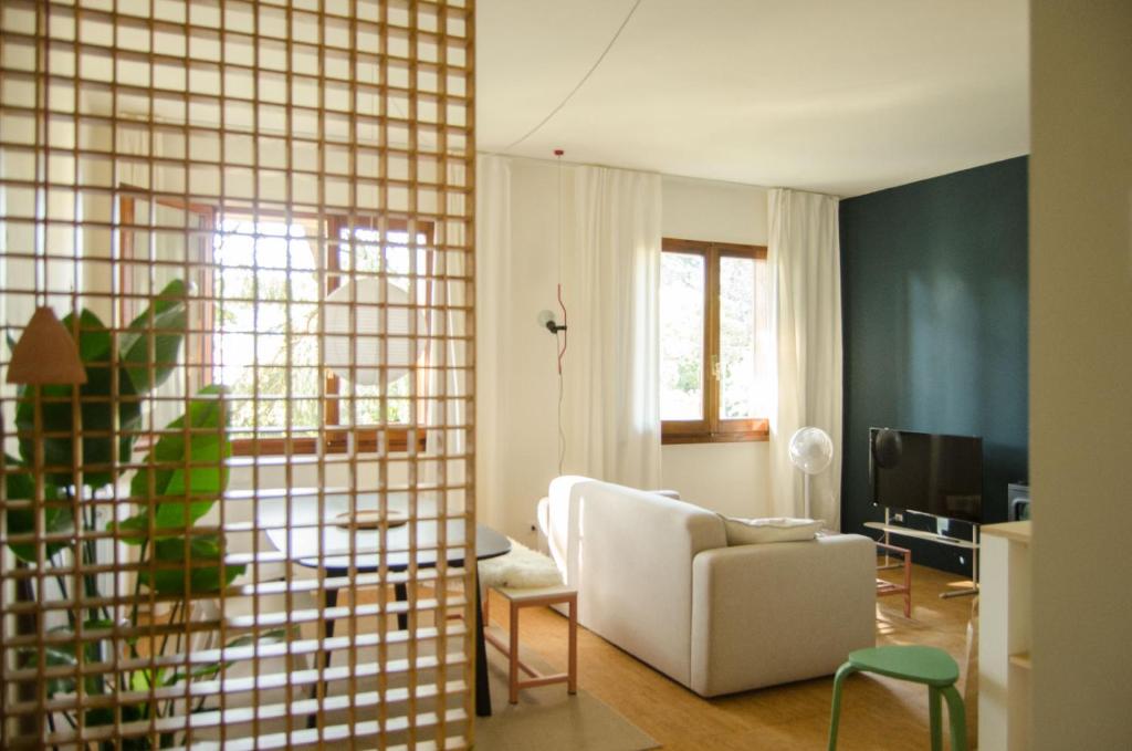 Beau Rivage - Suite Apartment in villa في سانتاركانجيلو دي رومانيا: غرفة معيشة مع أريكة بيضاء وطاولة