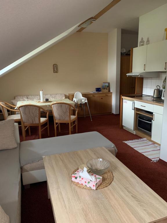 a living room with a table and a kitchen at Apartmán Viki in Philippsreut