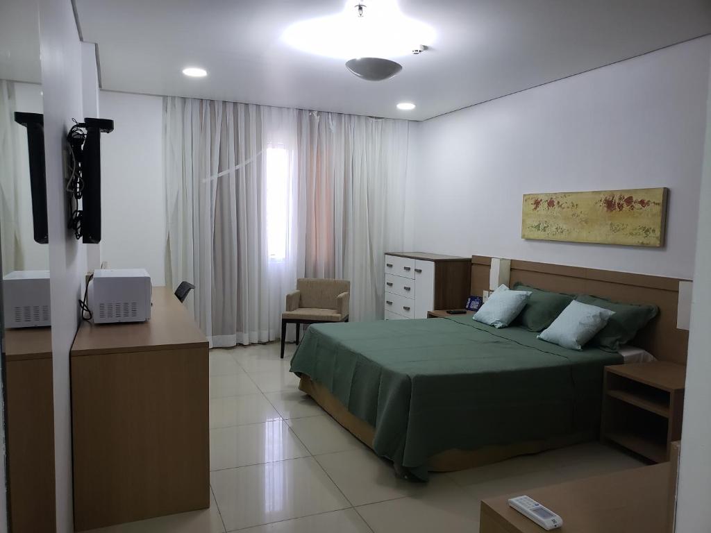 a bedroom with a bed and a desk and a television at Apto Hotel Blue Tree Manaus in Manaus