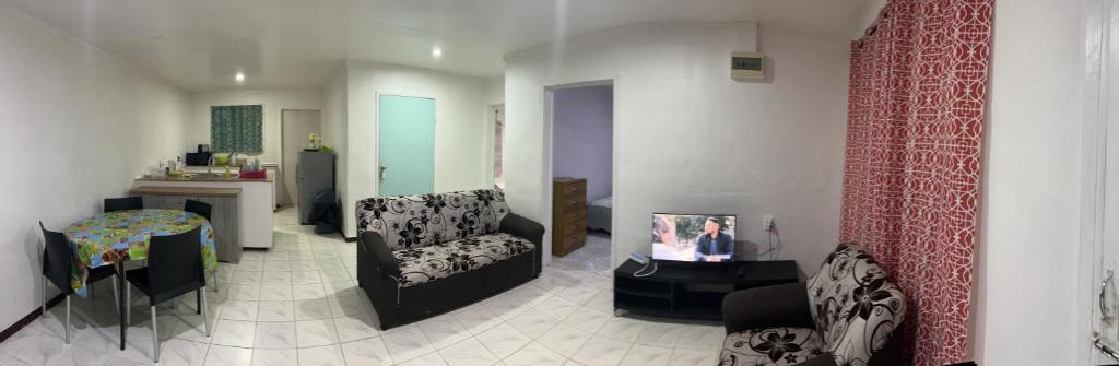 a living room with a couch and a tv in it at Mapusagas Riverside x2Bedrooms Home away from home #4 Sleeps 2-6 in Apia