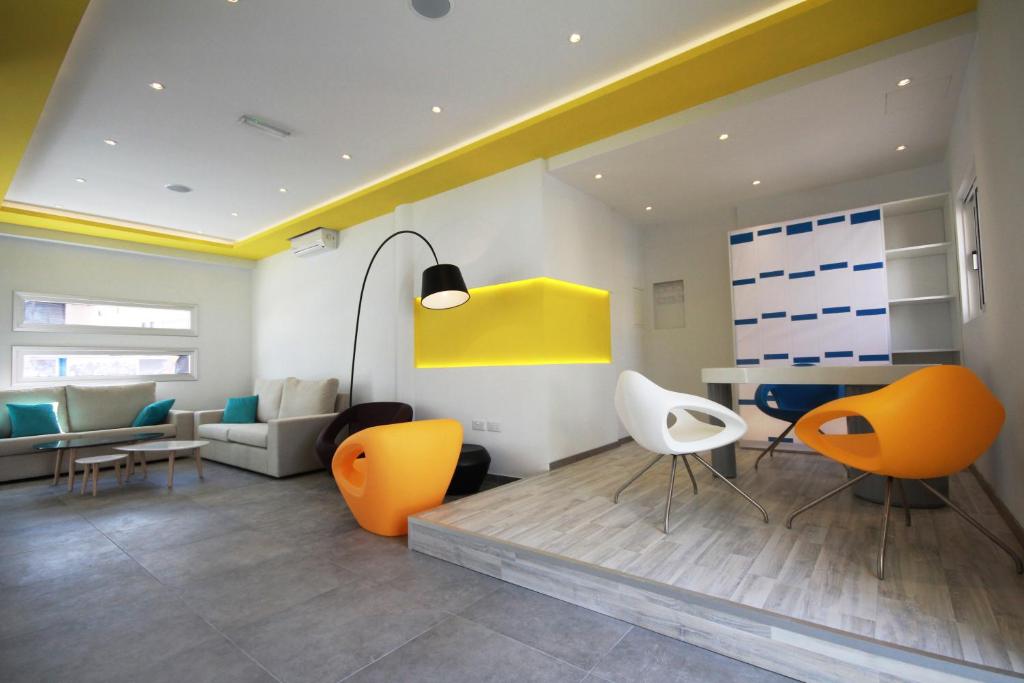 a living room with orange chairs and a table at Sea CleoNapa Hotel in Ayia Napa