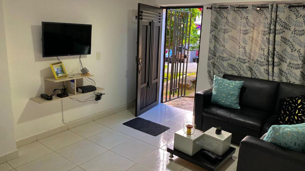 ein Wohnzimmer mit einem Sofa und einem TV in der Unterkunft Apartamento cerca helipuerto angar M45 Azotea in Medellín