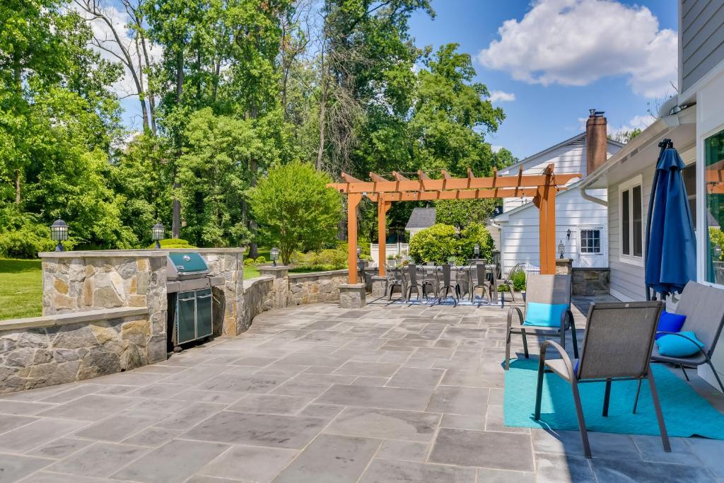 a patio with a fireplace and chairs and a stone wall at Rockville Home Patio Oasis, Fireplace, Near DC! in Rockville