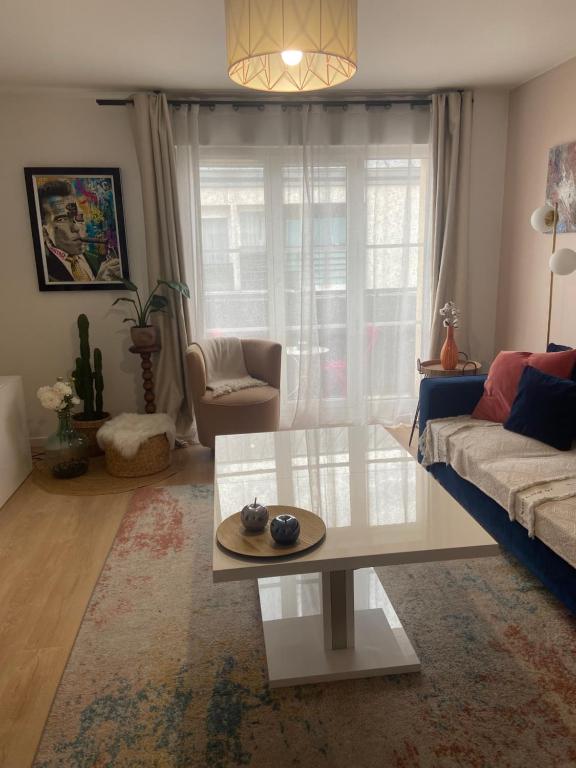 uma sala de estar com um sofá e uma mesa em Jessi home em Limeil-Brévannes