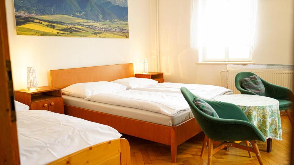 a bedroom with two beds and two chairs at Holiday House Mária in Závažná Poruba
