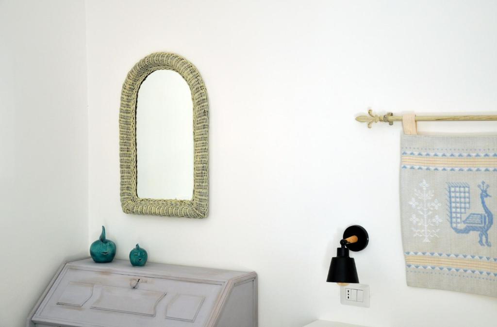 een spiegel aan een muur naast een tafel bij Baia delle foche in Fertilia
