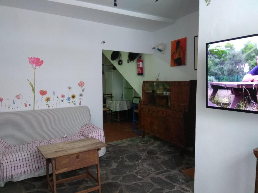 salon z kanapą i telewizorem w obiekcie El Regocijo Bajo w mieście Oliva de la Frontera