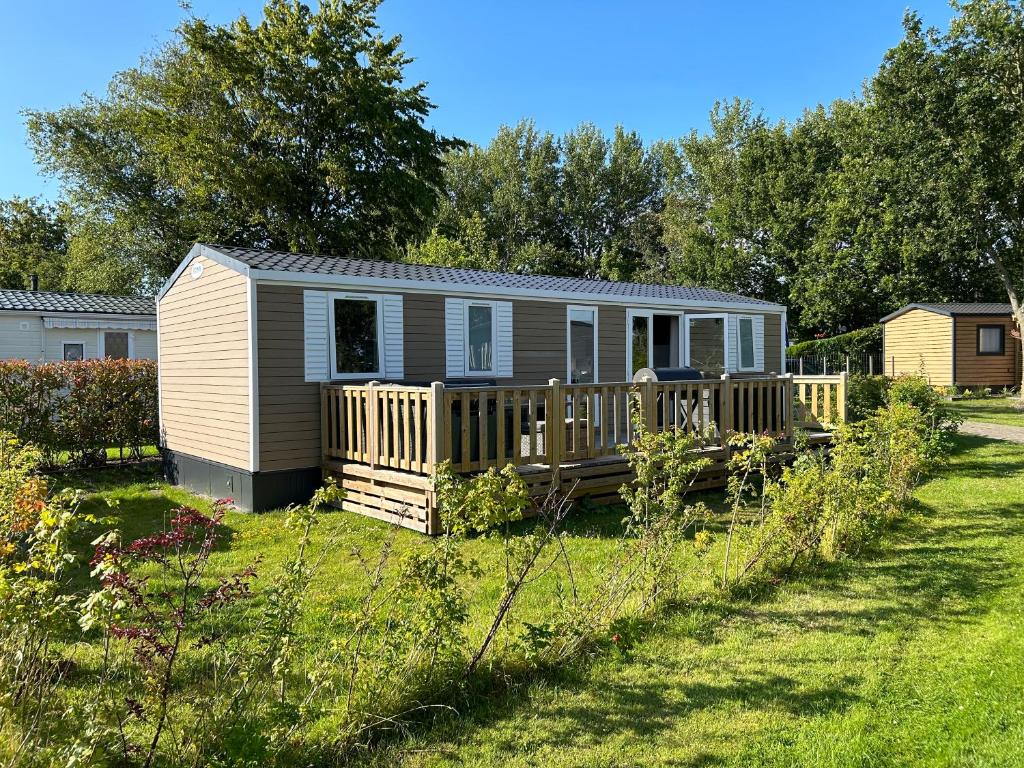 a tiny house on a deck in a yard at DS Chalets-Simonsgat 63-Geweldige 6 tot 7 persoons chalet met 2 badkamers-vakantiepark Lauwersoog-aan het Lauwersmeer in Lauwersoog