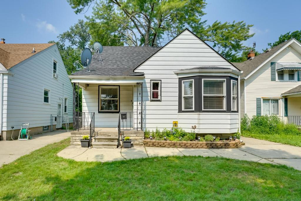a white house with a porch and a yard at Pet-Friendly Dearborn Home Less Than 2 Mi to Downtown! in Dearborn