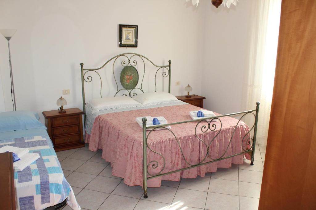 een slaapkamer met een bed met een roze sprei bij ALLOGGIO PREDIO VALCELLE in Acquapendente
