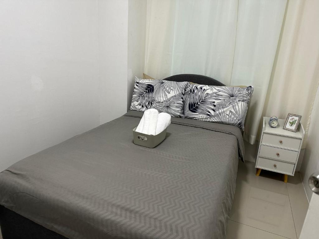a small bedroom with a bed and two pillows at Uptown CDO Staycation in Cagayan de Oro